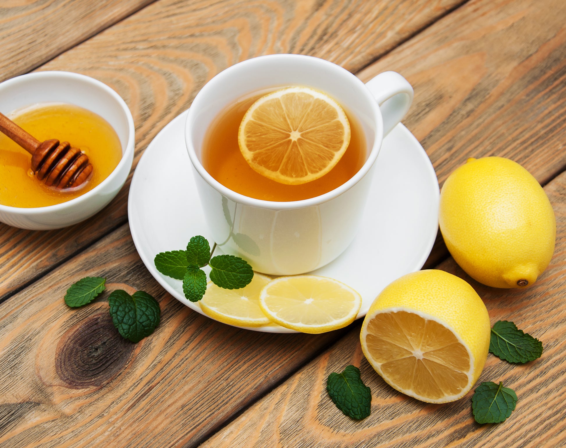Cup of tea with lemon and ginger on wooden surface